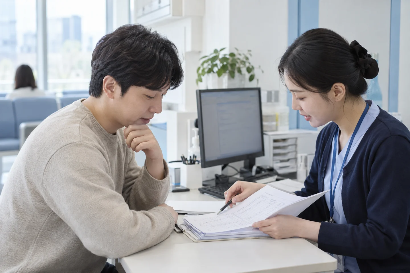 원무 담당자와 진료비 항목을 확인하는 남성